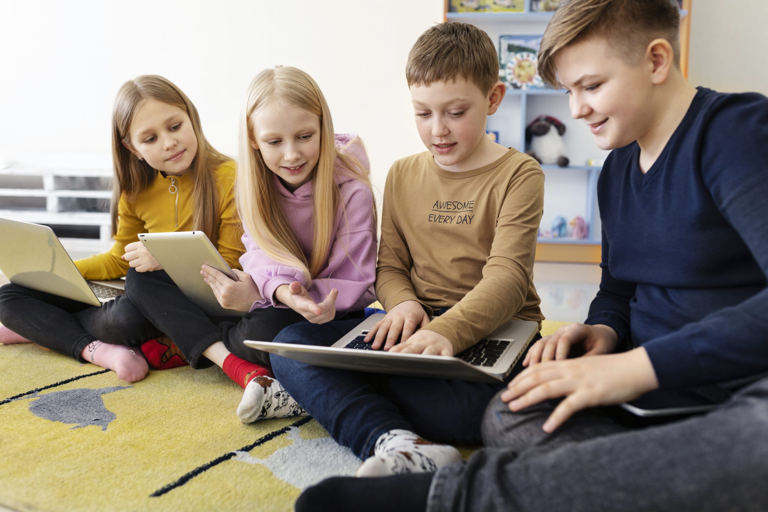 four-kids-working-together-using-their-laptops-tablets